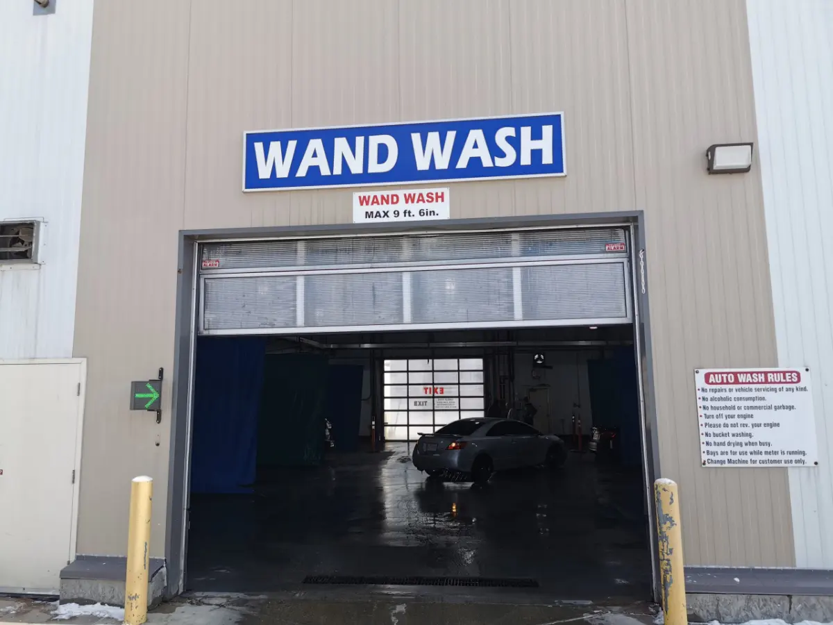 Car washing inside a wand wash bay at Arctic Autowash, Edmonton