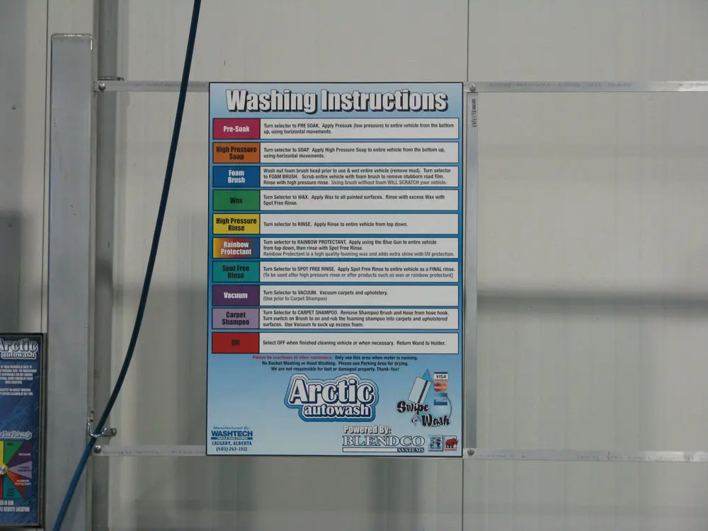 Washing instructions sign in a wand wash bay at Arctic Autowash